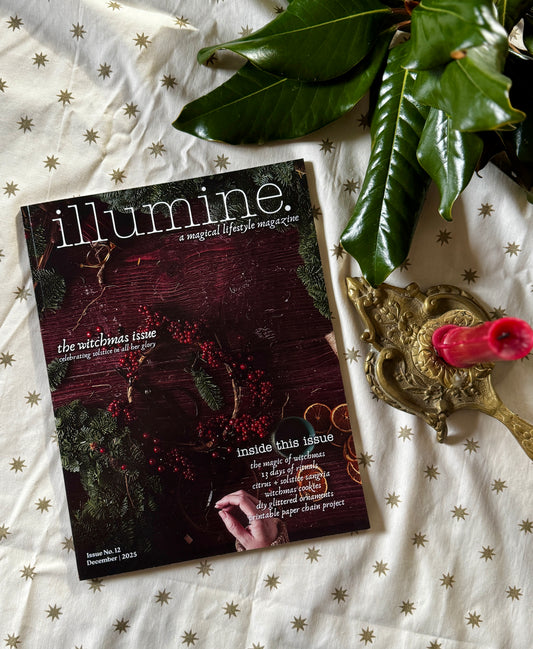 Magazine titled 'illumine' on a decorative surface with leaves and a candle.